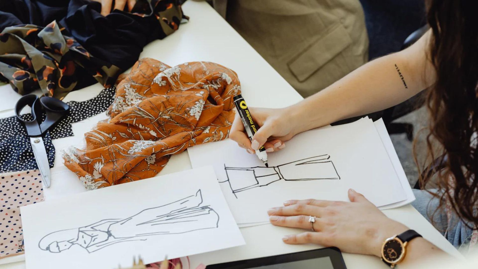 a fashion designer drawing pictures of clothes showing fashions designs 