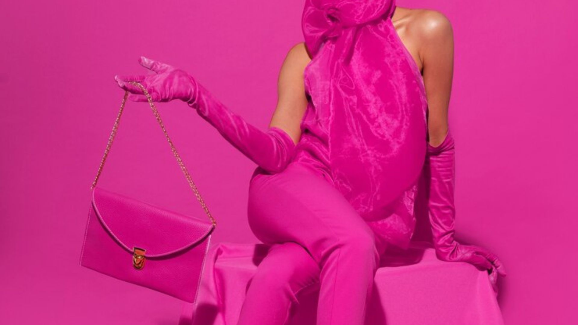 a lady wearing a pink outfit holding a pink bag