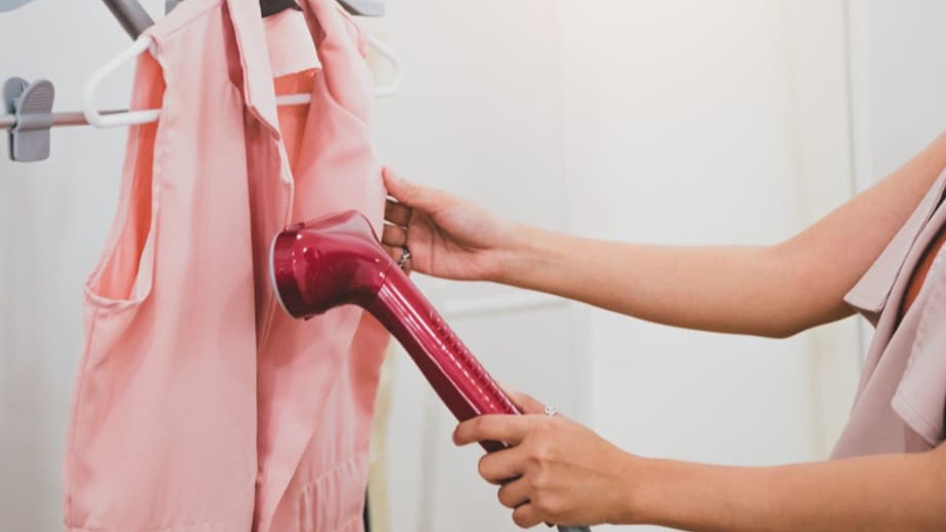 a lady ironing a pink top